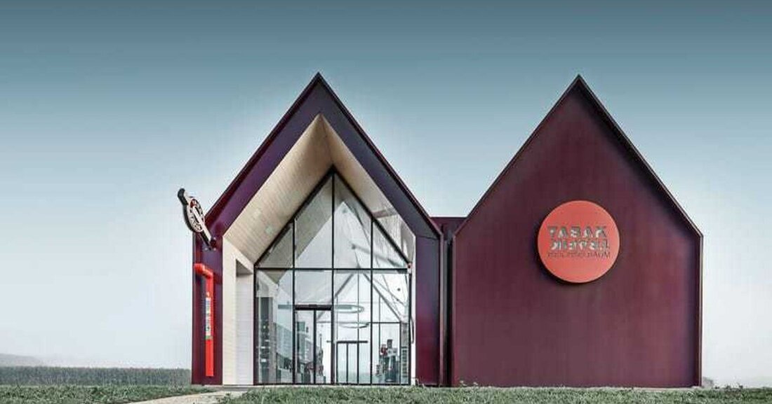 Zwei Spitzgiebel und die schwarz-rote Farbe für die Fassadenverkleidung sorgen mitten im baulich eher tristen Gewerbegebiet von St. Valentin in Oberösterreich für architektonische Furore. Ein neuer Tabakshop zeigt, dass auch kleine Zweckprojekte Megaauftritte in Sachen Architektur hinlegen können, wenn Bauherr, Architekt, Verarbeiter und Materialproduzent sich für das Thema gemeinsam erwärmen.